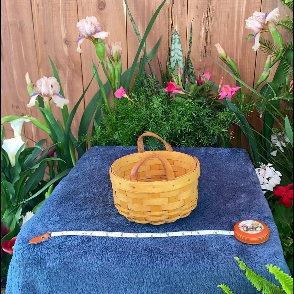 Circular basket with plastic insert and leather handles by Longaberger